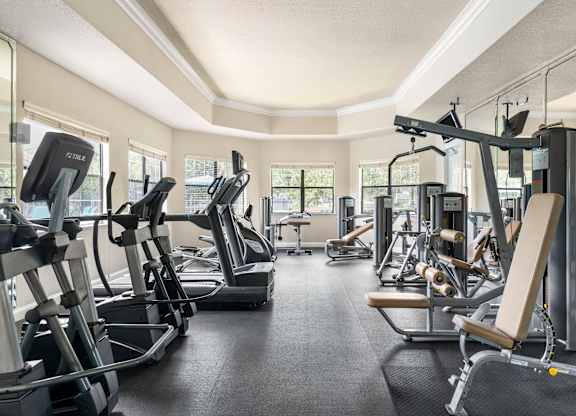A gym with treadmills, elliptical machines, and other exercise equipment.