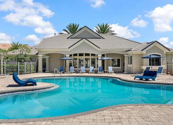 A house with a pool in front of it.