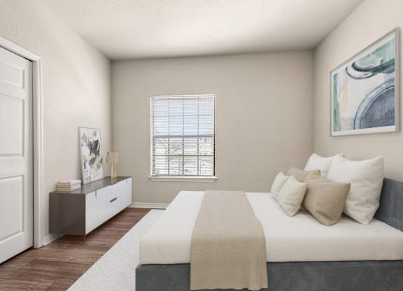 A bedroom with a bed, nightstand, and a window with blinds.