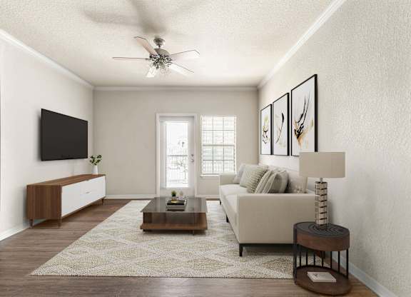 A living room with a white couch, a coffee table, and a ceiling fan.