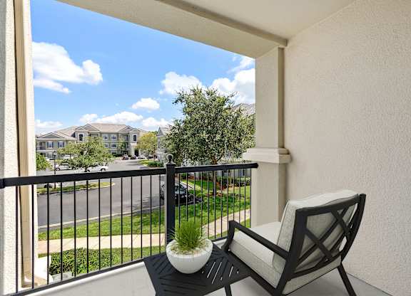 A balcony with a chair and a potted plant.