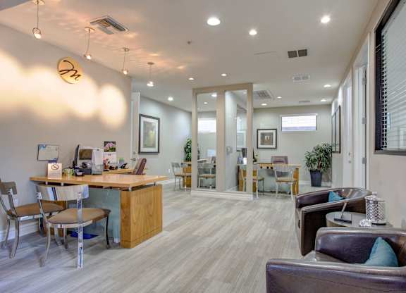 A well-lit waiting room with a reception desk and comfortable seating.