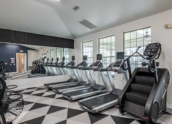 A gym with treadmills and elliptical machines.