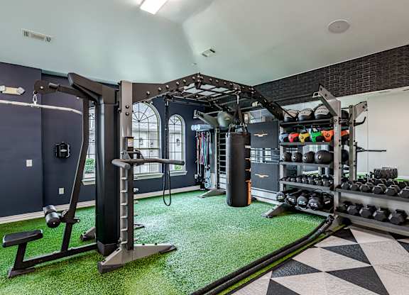 A gym with a green artificial turf floor and a black and white checkered floor.