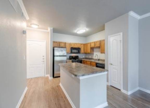 A kitchen with white cabinets and a wooden island.