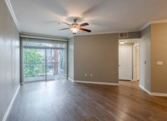 A room with a sliding glass door leading to a balcony.