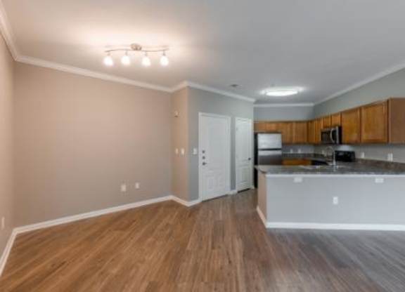 A kitchen with wooden floors and a white countertop.