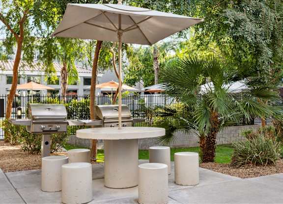 A patio with a table, chairs and umbrella.