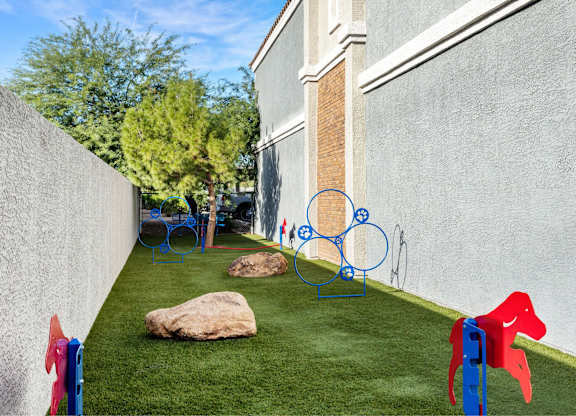 A playground with a red horse and a blue horse.
