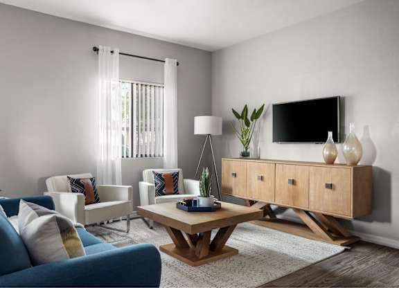 A living room with a blue sofa, a wooden coffee table, and a TV on a cabinet.