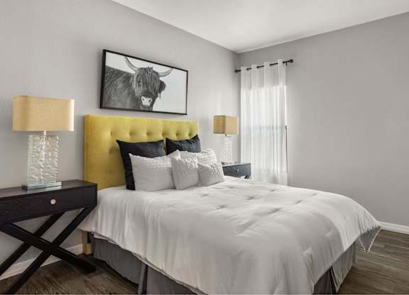 A bedroom with a yellow headboard and a white bedspread.