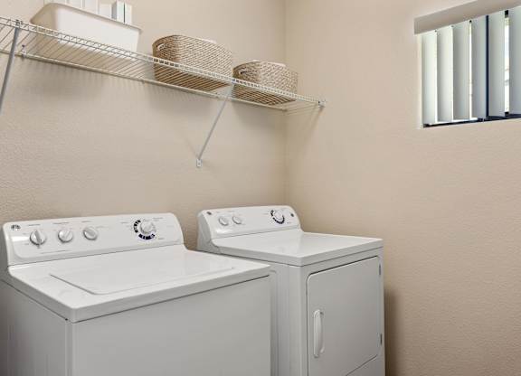A white washing machine and dryer in a small laundry room.