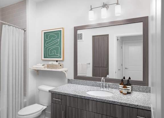 A bathroom with a white sink and a mirror above it.