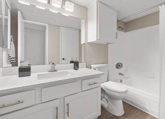 A white bathroom with a toilet, sink, and mirror.