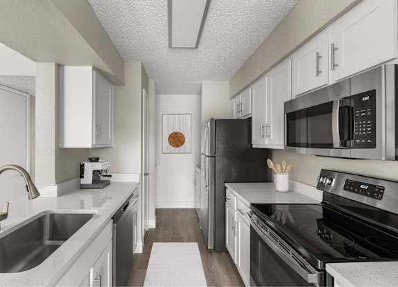 A modern kitchen with black appliances and white cabinets.