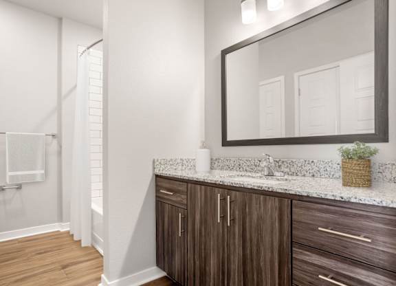 A bathroom with a wooden cabinet and a white countertop.