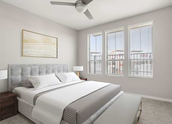 A bedroom with a large bed and a ceiling fan.