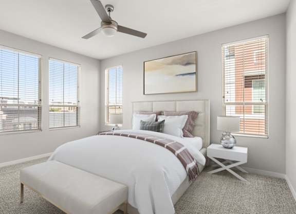 A bedroom with a large bed and a ceiling fan.