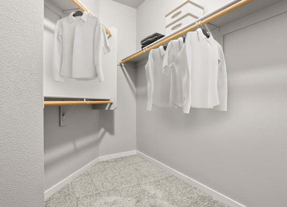 A white shirt is hanging on a wooden hanger in a white closet.