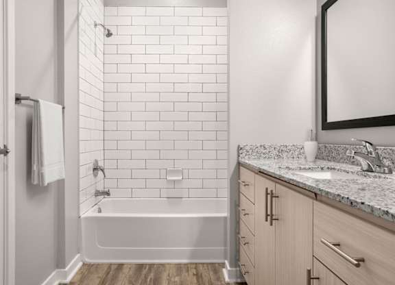 A white tiled bathroom with a wooden floor.