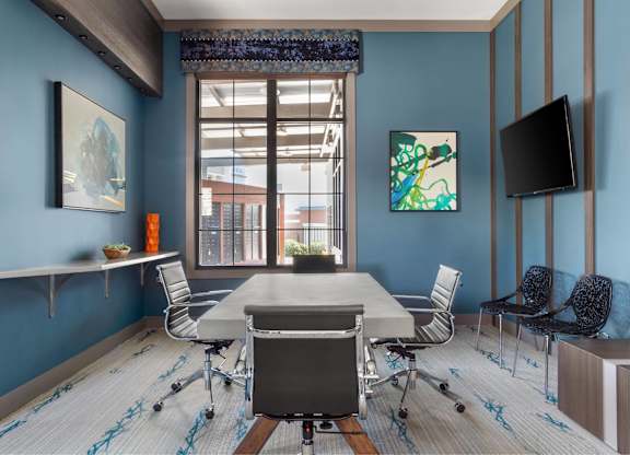 A conference room with a long table and chairs.