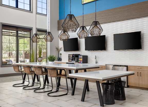 A modern dining room with a long table and chairs.