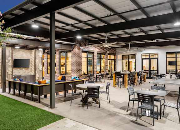 A patio with tables and chairs is set up outside a building.