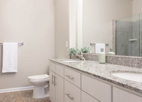 A white toilet sits in a bathroom with a glass shower door.