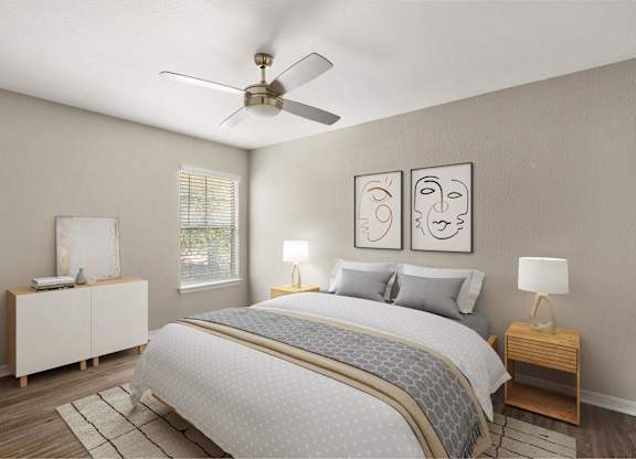 A bedroom with a bed, nightstands, and a ceiling fan.