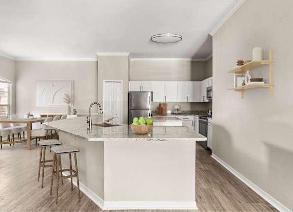 A kitchen with a white island and wooden floors.