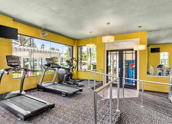 A gym with treadmills and a television.