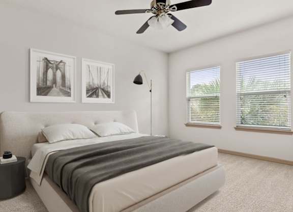 A bedroom with a large bed and two pictures on the wall.