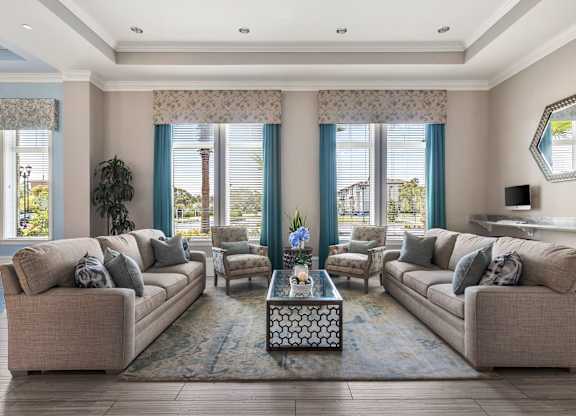 A living room with two couches, a coffee table, and a large window with blue curtains.