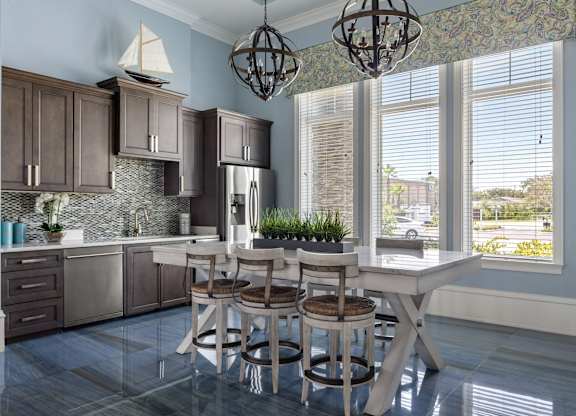A kitchen with a table and chairs in front of a window.