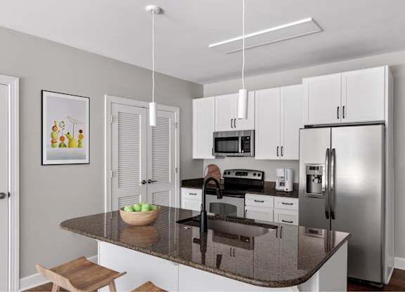 A modern kitchen with a granite countertop and stainless steel appliances.
