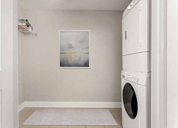 A laundry room with a washing machine and a painting on the wall.