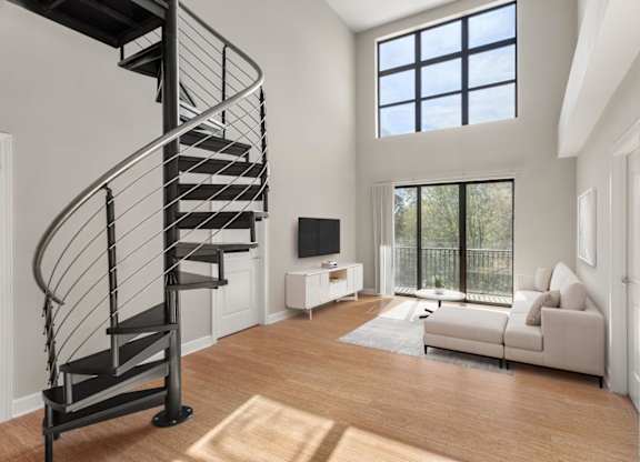 A living room with a spiral staircase and a couch.