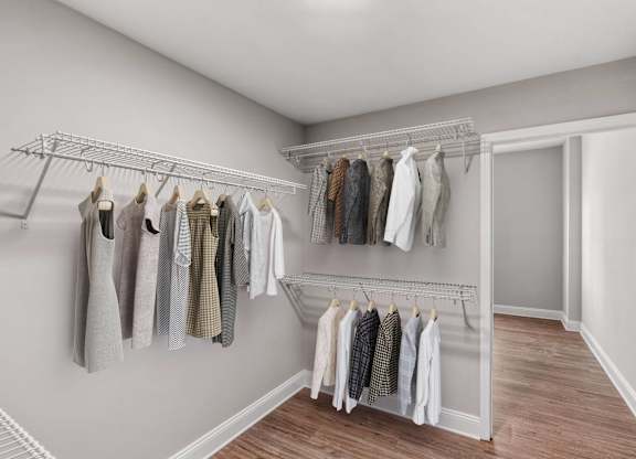 A white wall with clothes hanging on a rack.