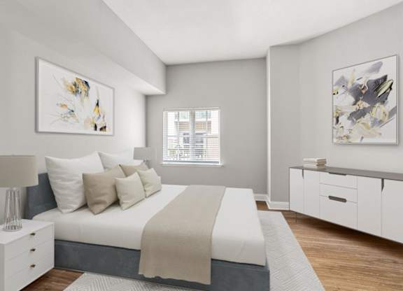 A bedroom with a large bed and two pieces of artwork on the wall.