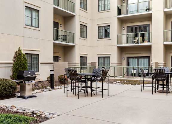A patio with a table and chairs in front of a building.