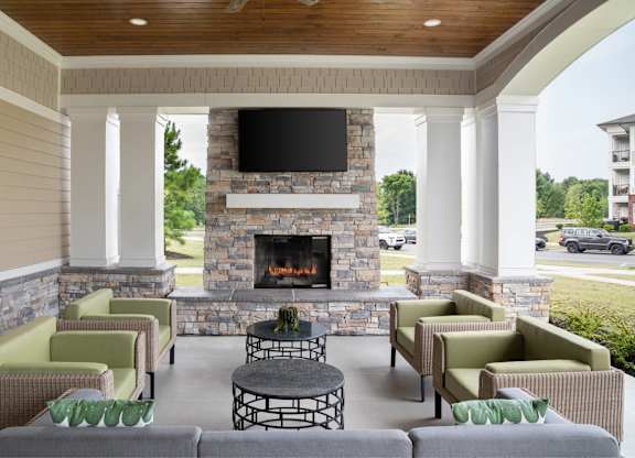 A patio with a fireplace and chairs.