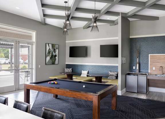 A room with a pool table and a television.