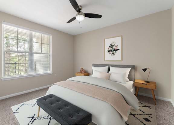A bedroom with a large bed, a ceiling fan, and a window with blinds.