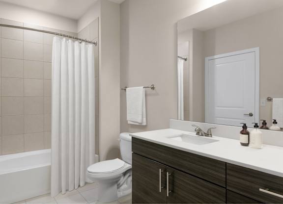 A white bathroom with a toilet, sink, and shower.