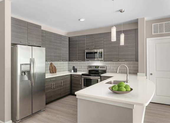 A modern kitchen with a stainless steel refrigerator and a white countertop.