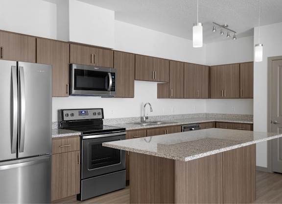 A kitchen with a refrigerator, oven, microwave, and sink.