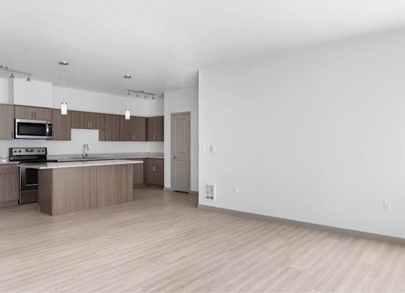 A kitchen with a microwave, oven, and sink.
