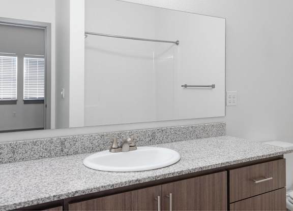 A bathroom with a sink, mirror, and toilet.