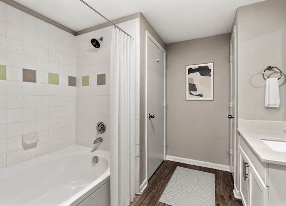 A white bathroom with a white tub and a white sink.