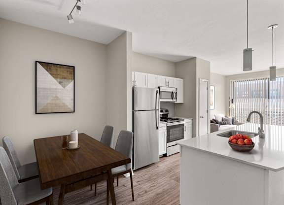 A modern kitchen with a wooden dining table and grey chairs.